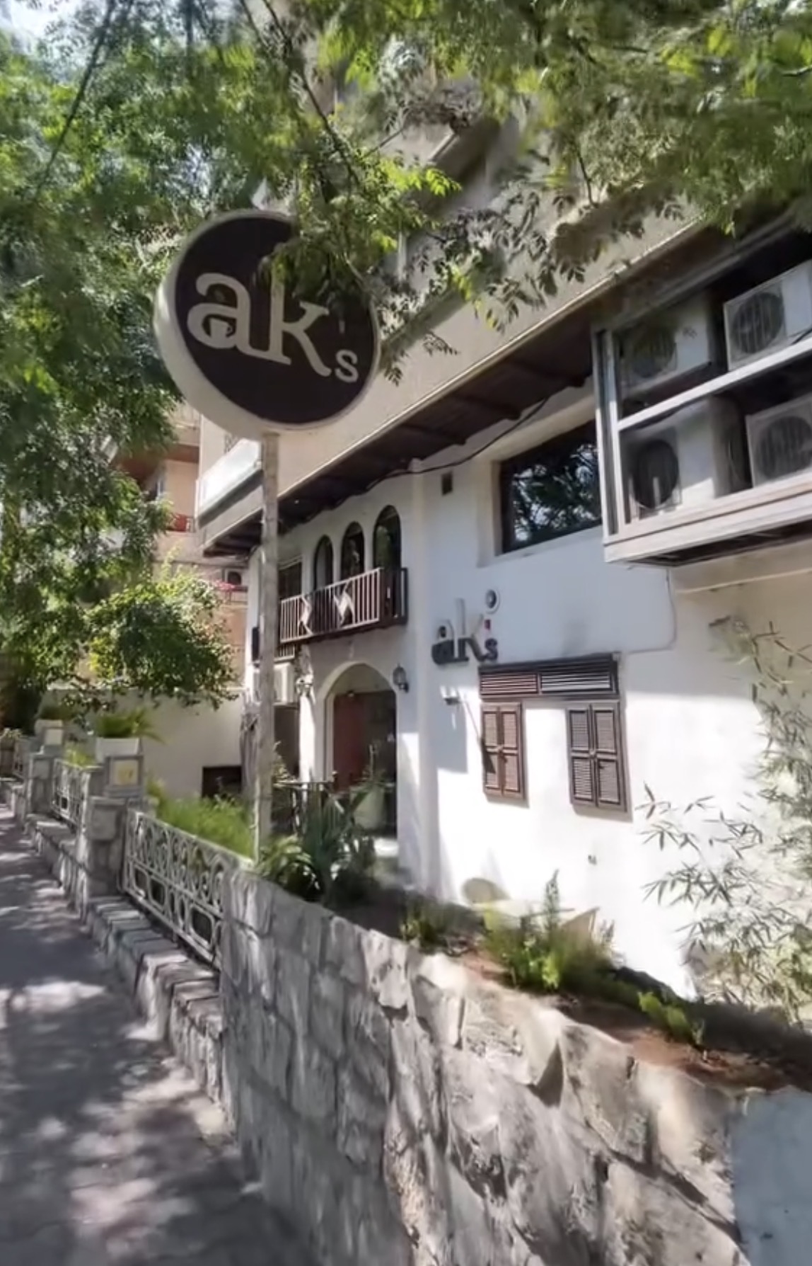 Exterior of AK's Coffee House with its circular street sign